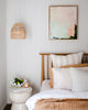 Modern pastel Australian abstract artwork hangs in coastal boho style bedroom with earthy and white decor