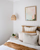 Modern pastel pink and mint Australian abstract art hangs in coastal boho style bedroom with neutral and white decor